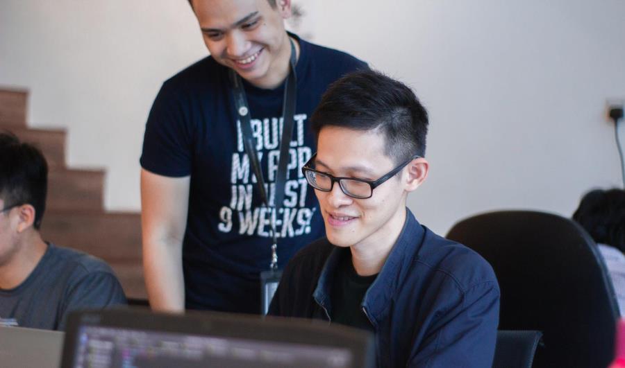 two students at a computer smiling